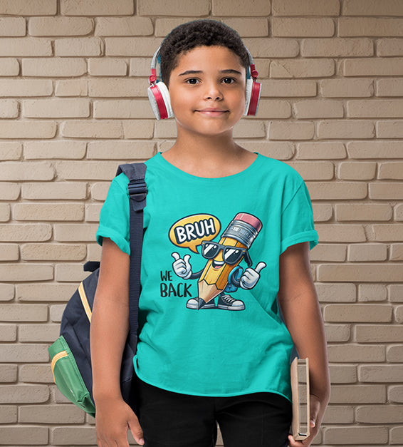 Young school-aged child wearing a teal blue t-shirt with a funny cartoon pencil graphic and the text “BRUH, WE BACK.” The kid is wearing headphones, holding a book, and standing in front of a beige brick wall. Ideal for back-to-school outfits