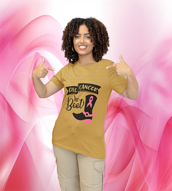 Woman wearing must “Give C the Boot” awareness T-shirt featuring a black cowgirl boot with a pink ribbon design, smiling and pointing at the design.