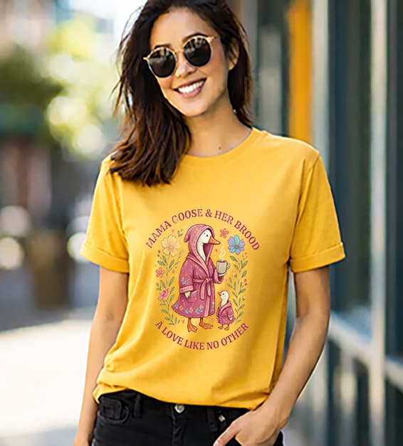 woman wearing a gold t-shirt with mama goose and baby goose illustration and text mama goose and her brood a love like no other