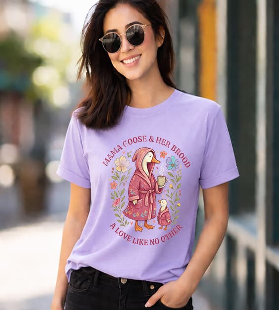 woman wearing a lavender t-shirt with mama goose and baby goose illustration and text mama goose and her brood a love like no other