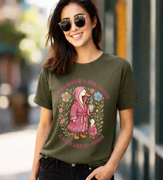 woman wearing a olive t-shirt with mama goose and baby goose illustration and text mama goose and her brood a love like no other