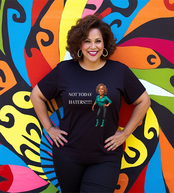 Woman wearing a black Bella Canvas t-shirt with motivational “Not Today Haters” graphic design in front of colorful mural background.
