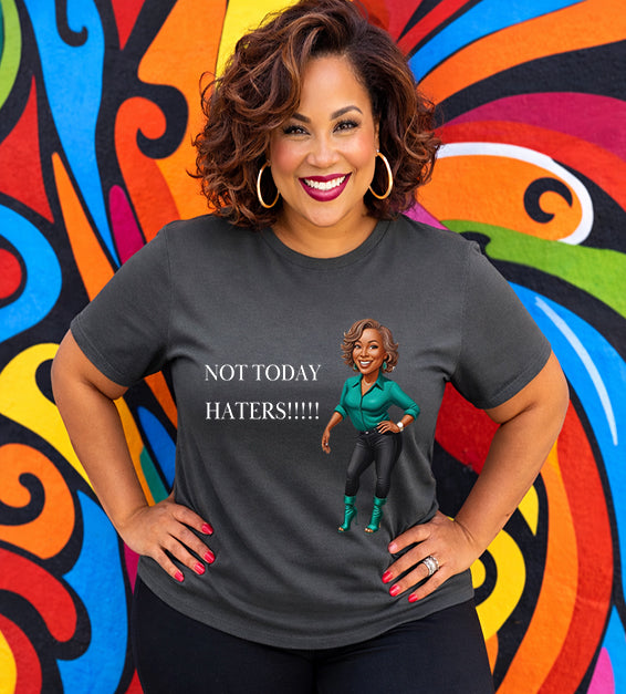 Woman wearing a dark grey Bella Canvas t-shirt with motivational “Not Today Haters” graphic design in front of colorful mural background.