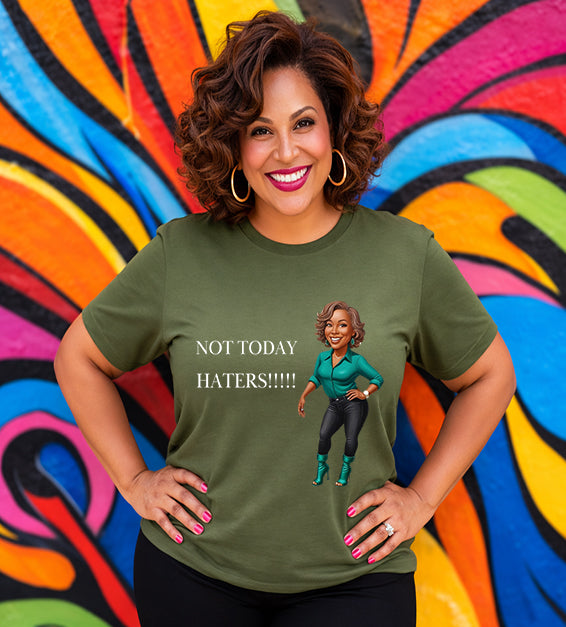Woman wearing a olive Bella Canvas t-shirt with motivational “Not Today Haters” graphic design in front of colorful mural background.