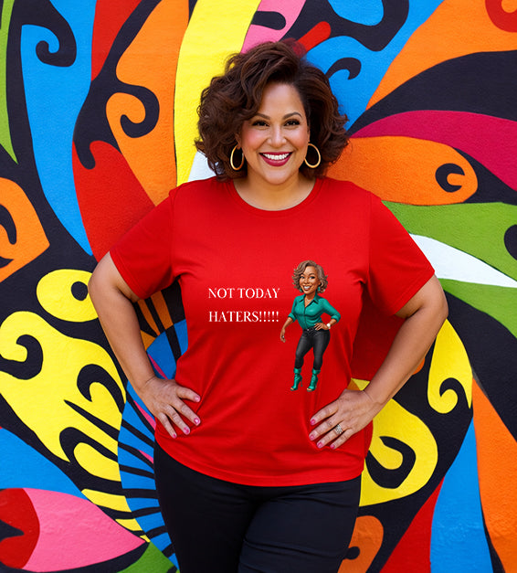 Woman wearing a red Bella Canvas t-shirt with motivational “Not Today Haters” graphic design in front of colorful mural background.