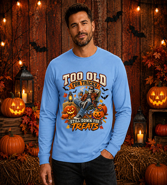Man wearing Carolina blue Too Old for Tricks Still Down for Treats Halloween long sleeve shirt with skeleton and pumpkin graphic